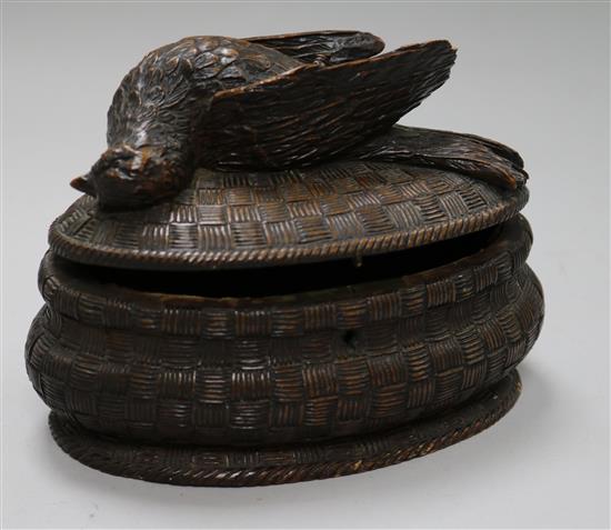 A carved oval wooden box with a bird carved lid